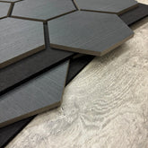 Hexagonal black tiles on a wooden surface