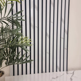 Black and white striped wallpaper with a plant in the foreground