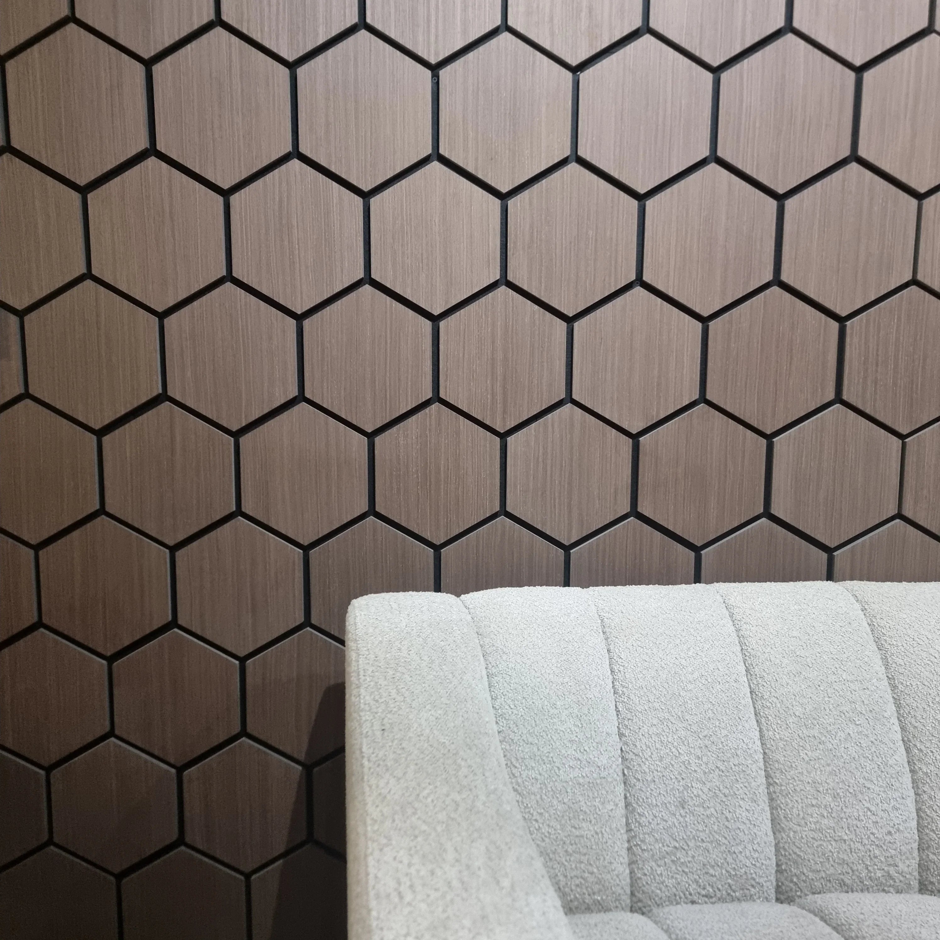 Hexagonal tile pattern on a wall with a gray sofa in the foreground