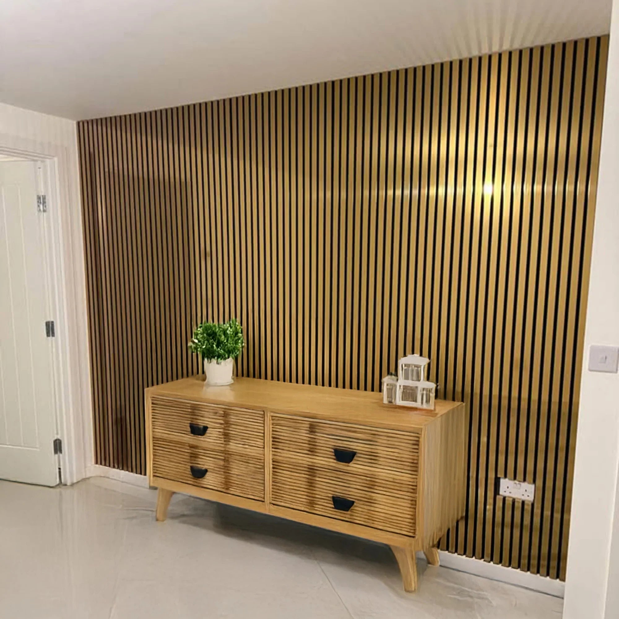Wooden sideboard with decorative items against a striped wall.