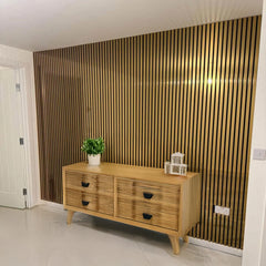 Wooden sideboard with decorative items against a striped wall.